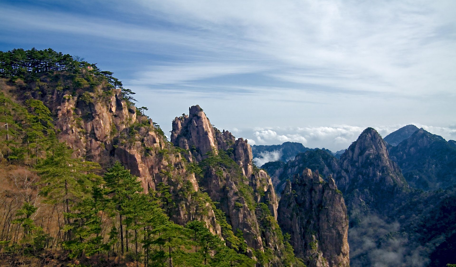Granite peaks and pine trees above a bank of cloud in the Huangshan mountains — Photo: Chi King / CC BY 2.0 via Wikimedia Commons