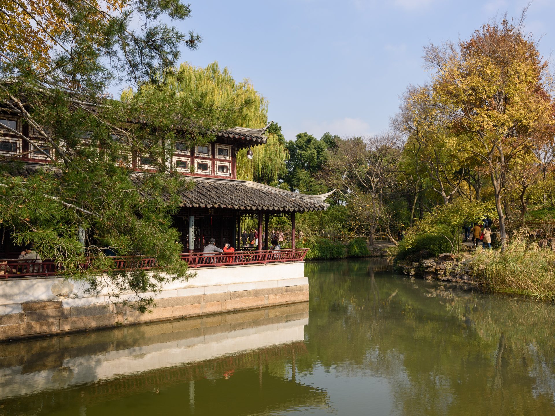 Waterside hall of the Humble Administrator's Garden in Suzhou with still water reflecting trees in autumn — Photo: King of Hearts / CC BY-SA 4.0 via Wikimedia Commons