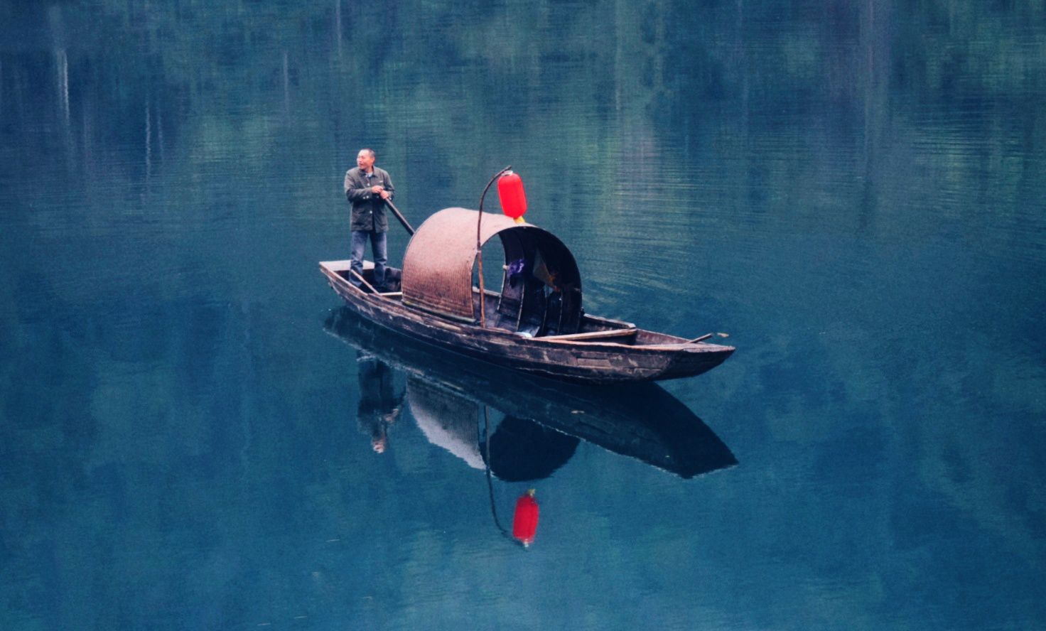 A boat on Dongjiang Lake between mist windows