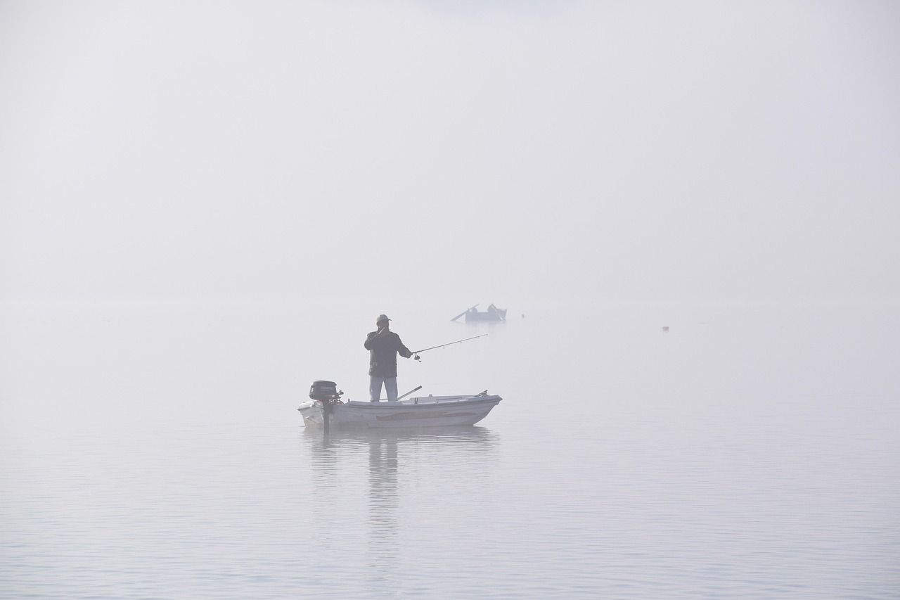 A fisherman on a mist-covered river — the classic Xiaodongjiang scene
