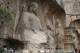 The giant Vairocana Buddha and attendant figures carved into the cliff at Fengxian Temple, Longmen Grottoes, Luoyang